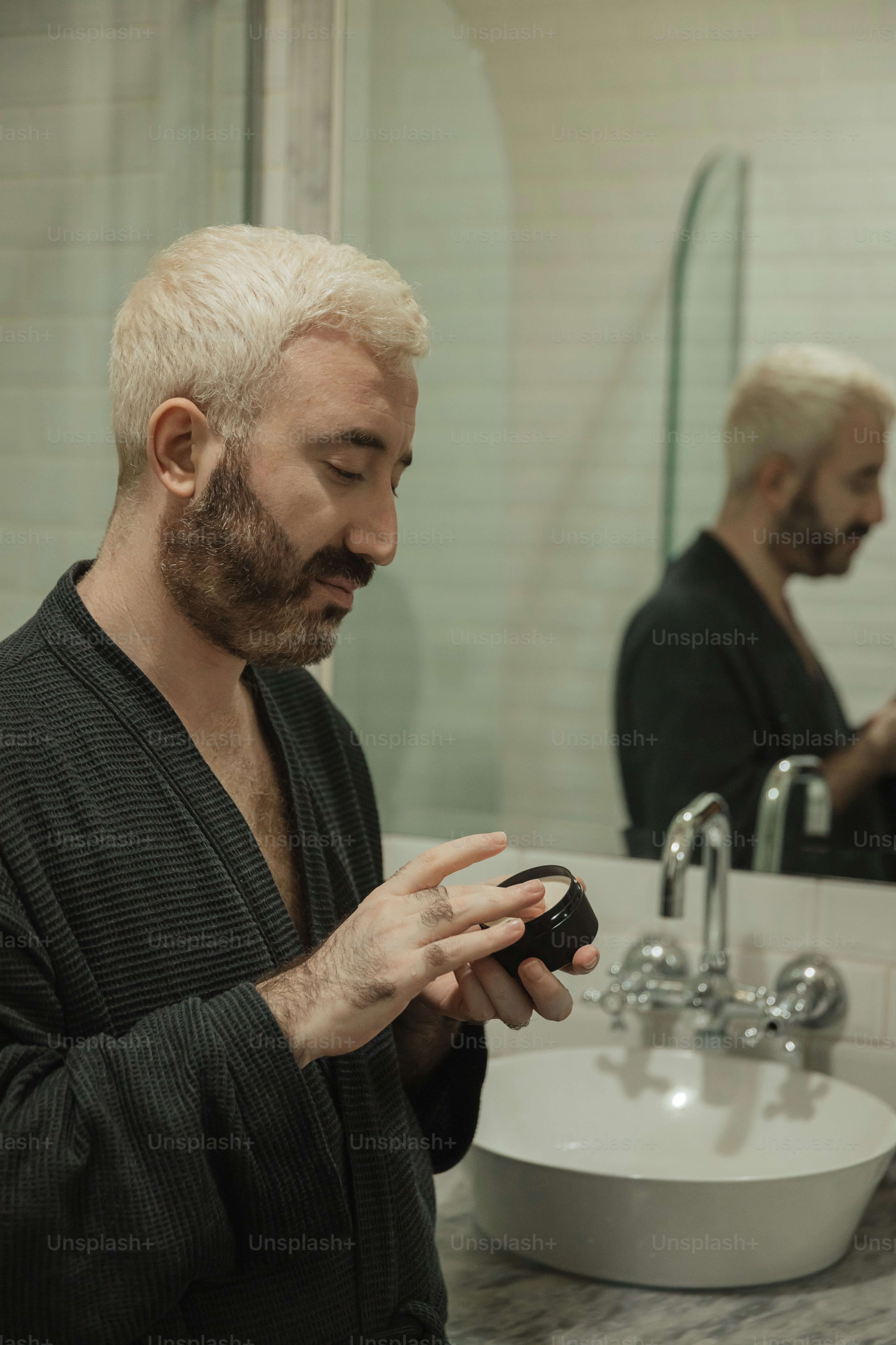 a man in a bathrobe looking at his cell phone
