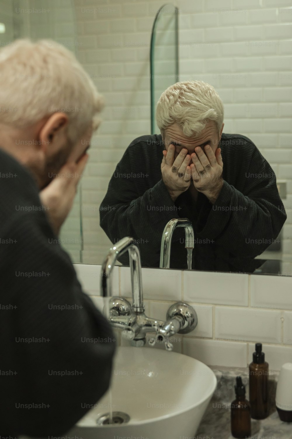 a man is looking at his reflection in the mirror