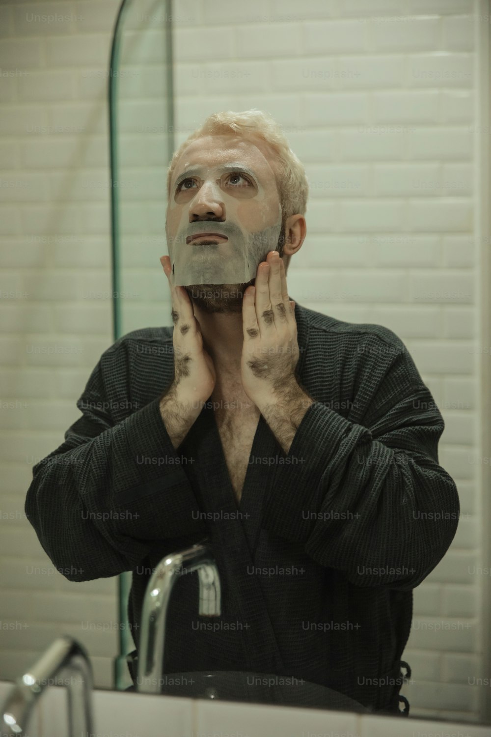 a man is shaving his face in front of a mirror