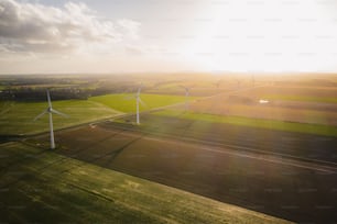 an aerial view of wind turbines in a green field