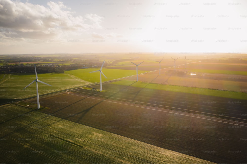 an aerial view of wind turbines in a green field