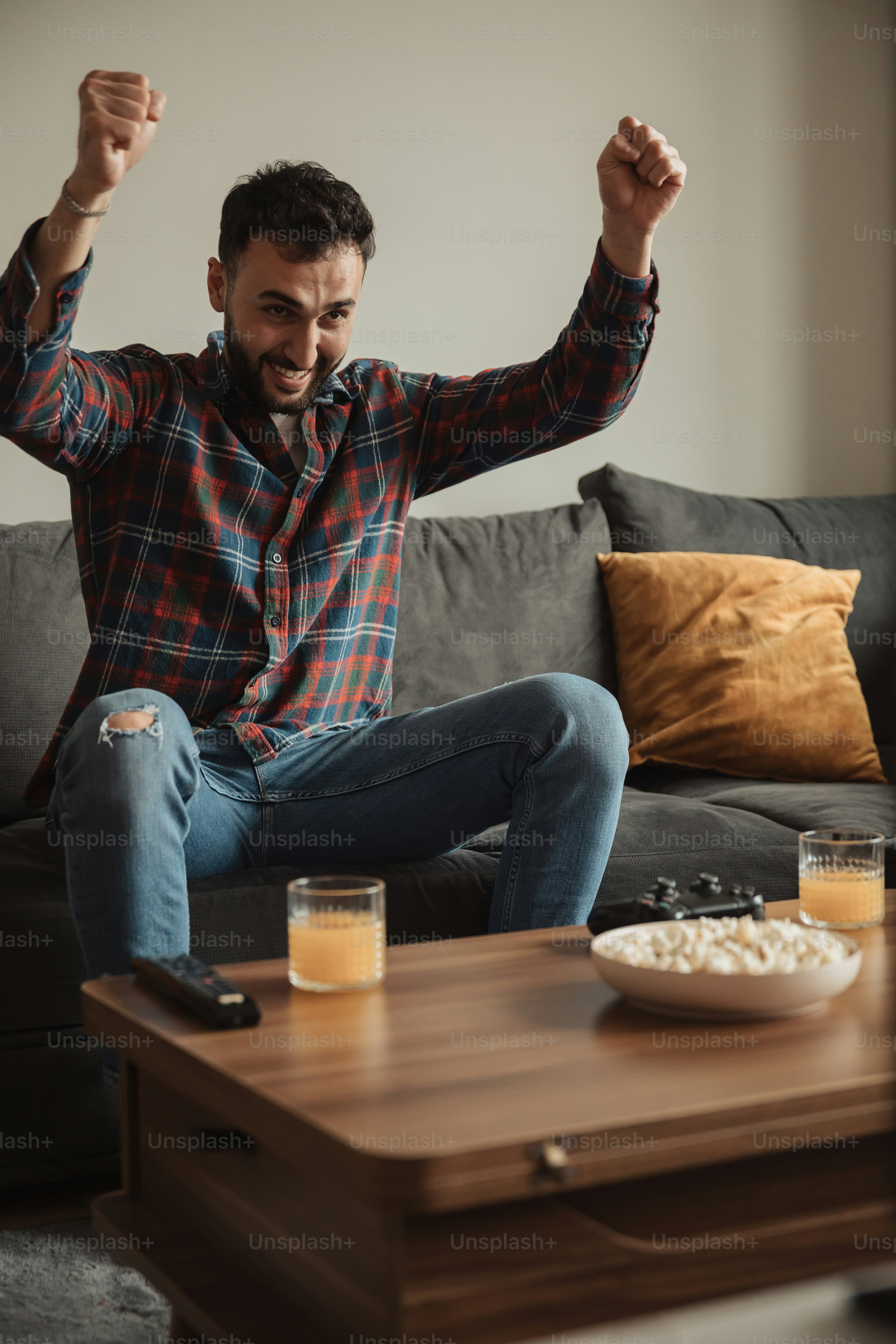 um homem sentado em um sofá com os braços no ar