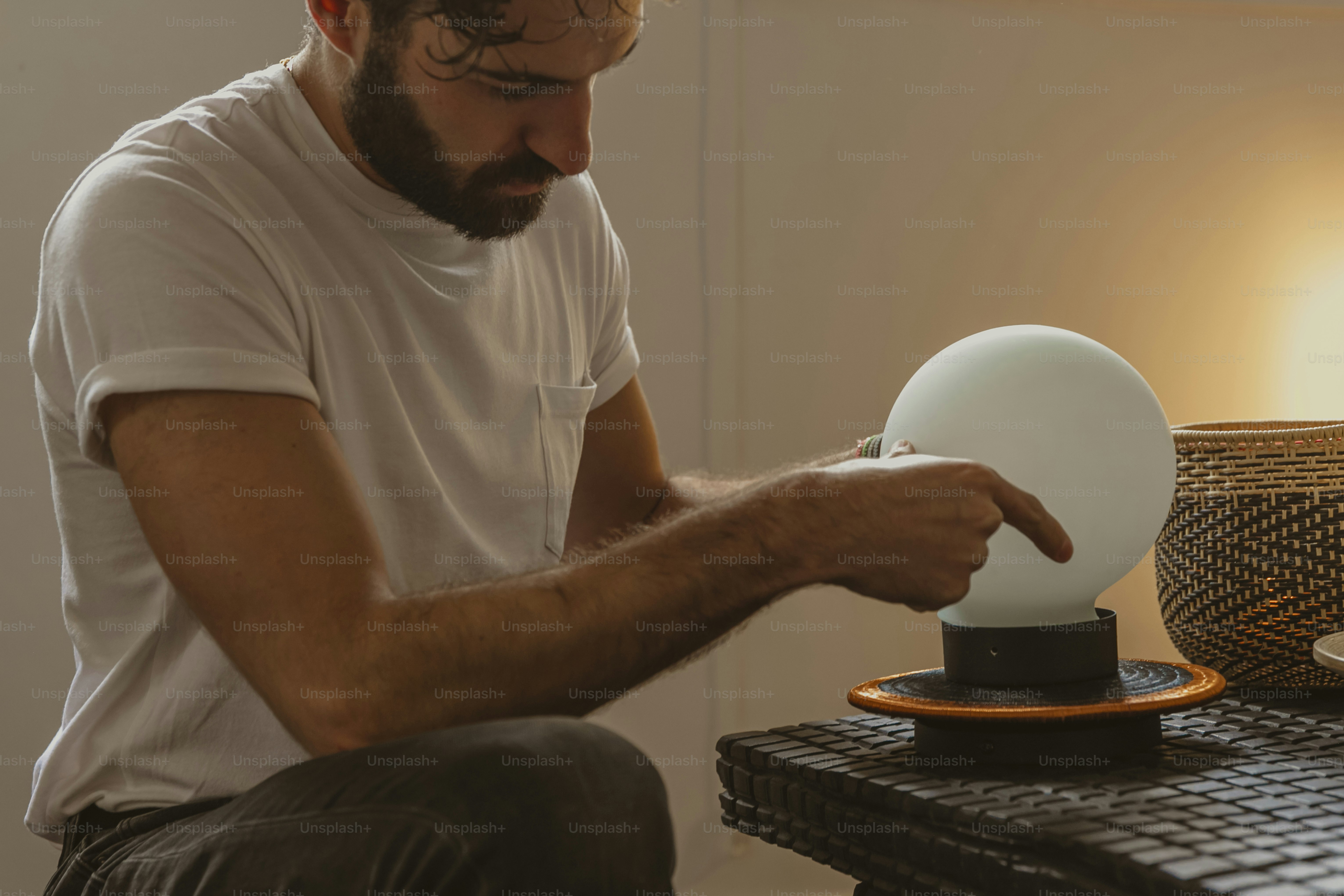 Ein Mann sitzt an einem Tisch mit einer weißen Kugel darauf