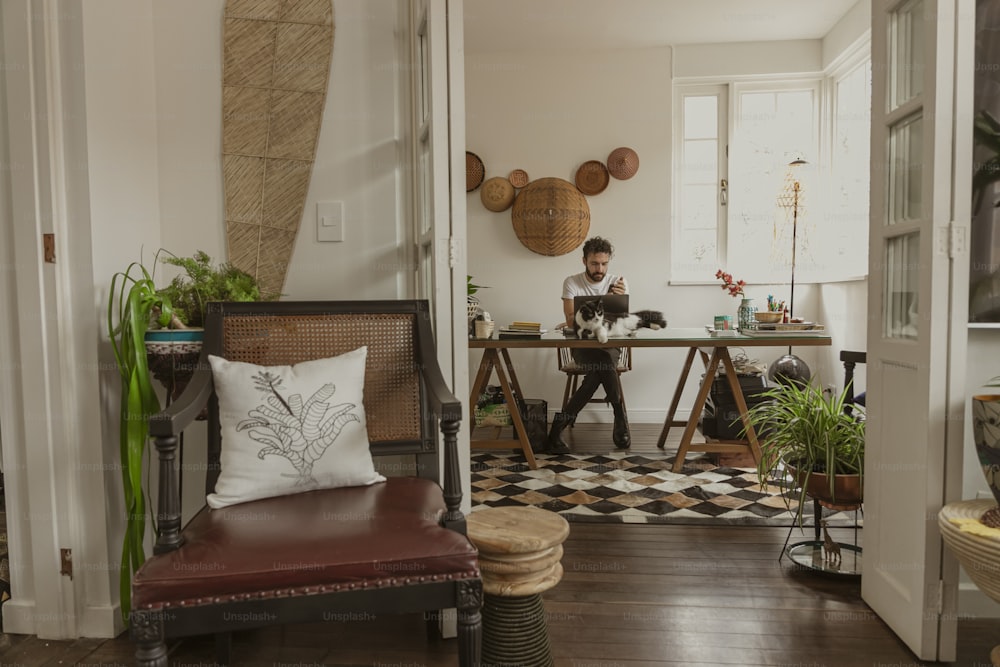 um homem sentado em uma mesa em uma sala de estar