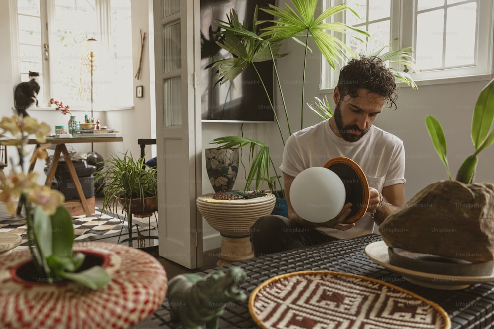 a man sitting at a table holding an egg