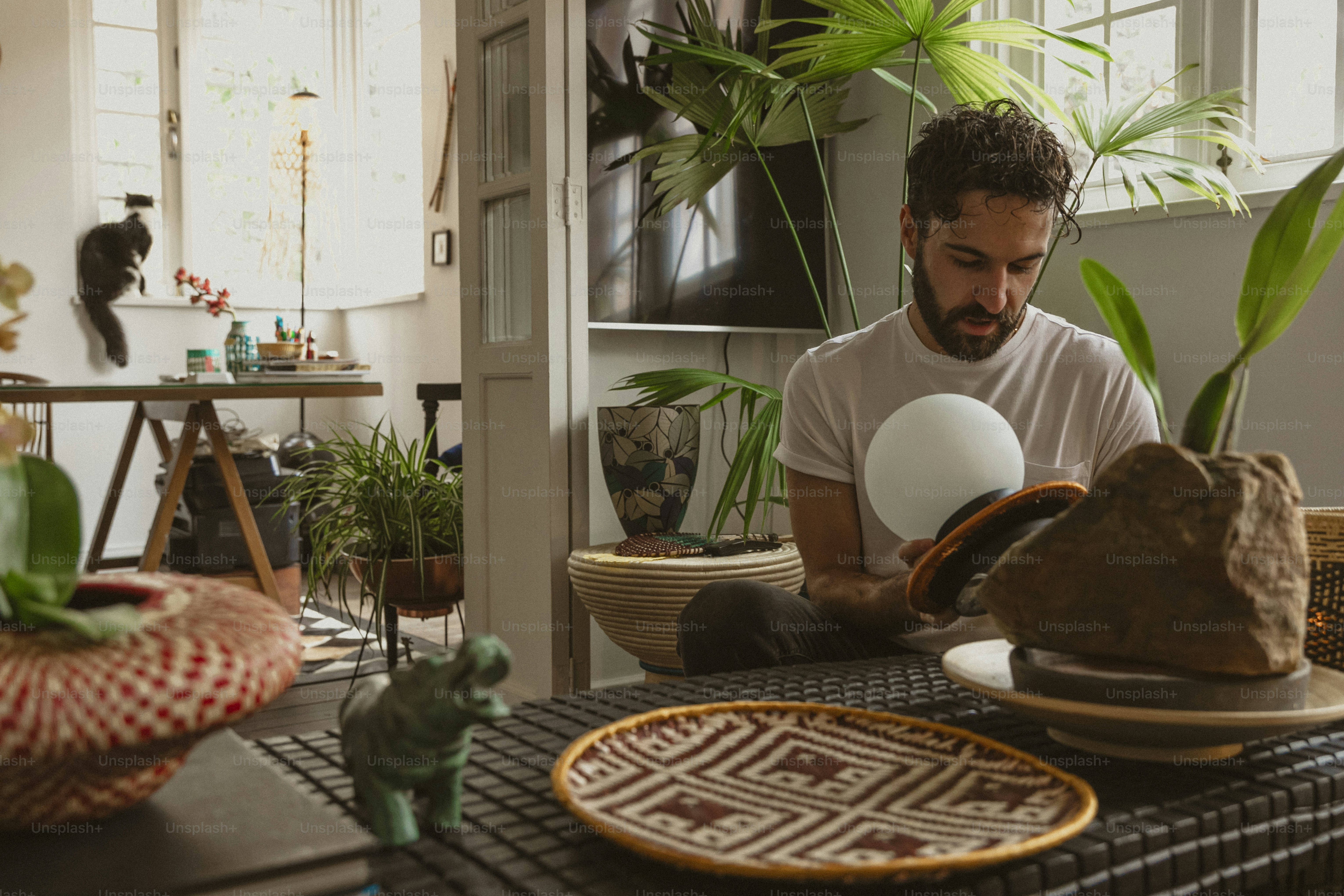 Ein Mann sitzt an einem Tisch vor einer Fabrik