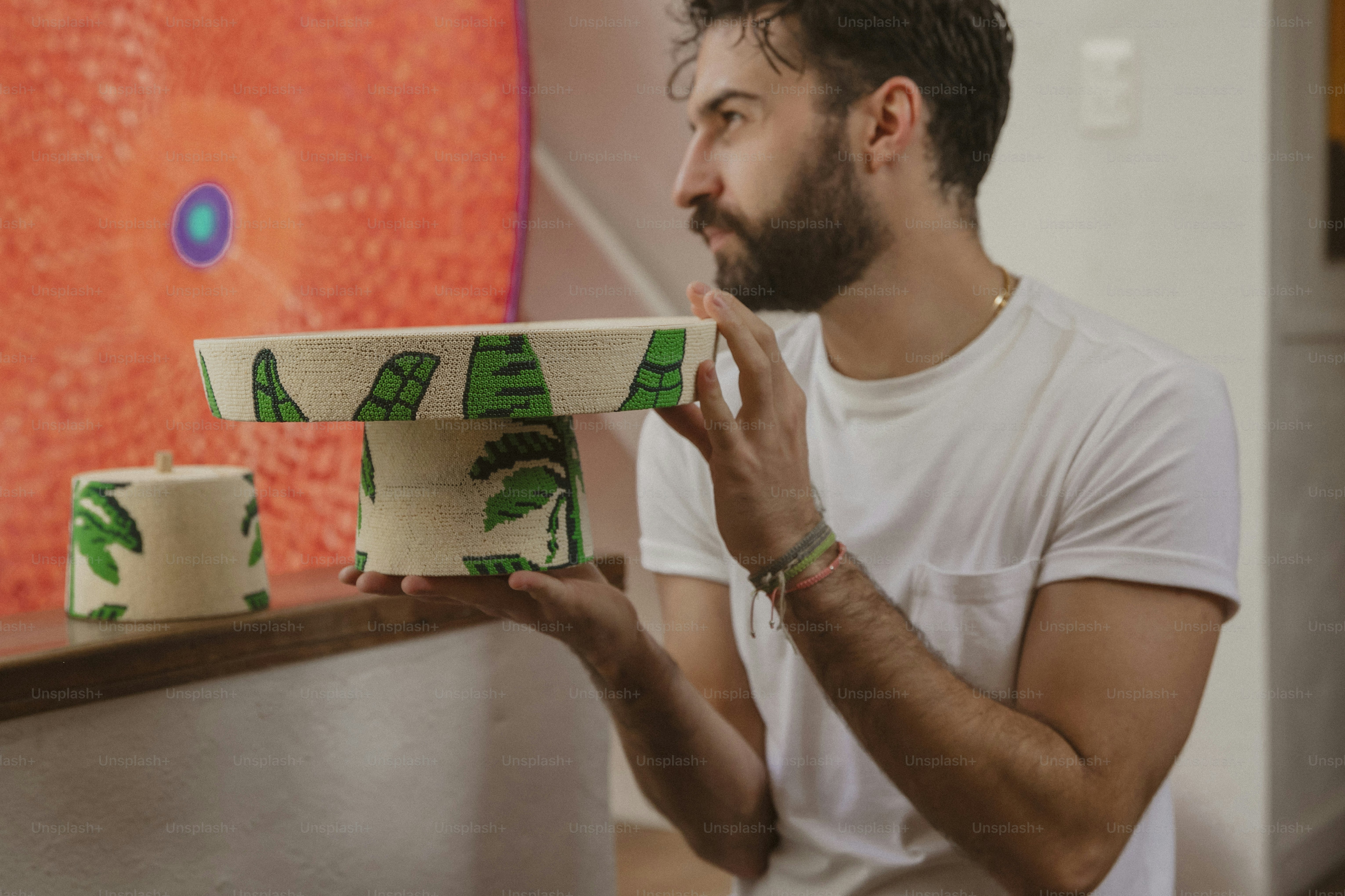 a man holding a bowl with palm trees painted on it