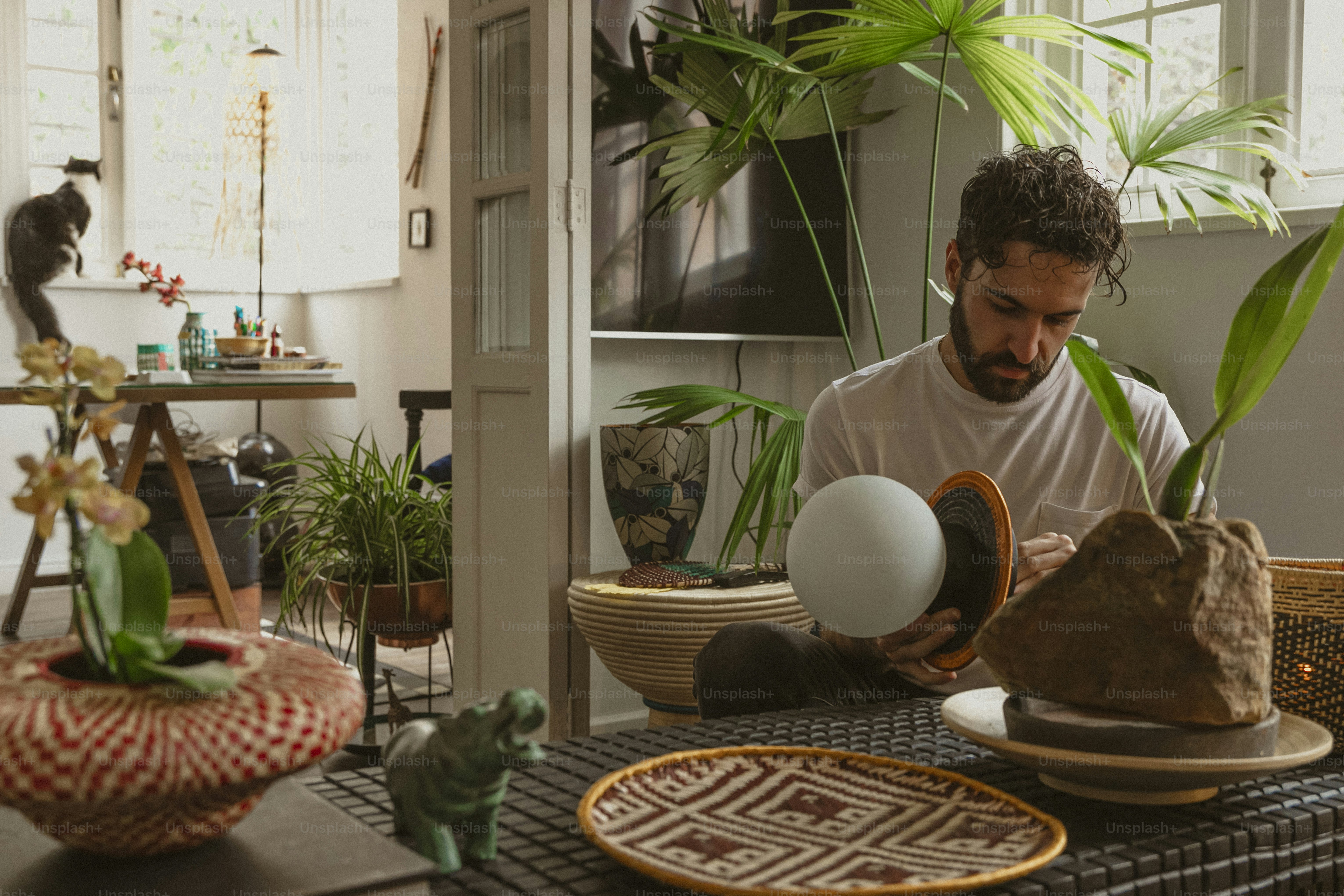 Ein Mann sitzt an einem Tisch und hält ein Ei in der Hand