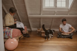 um homem e uma mulher sentados no chão com um gato