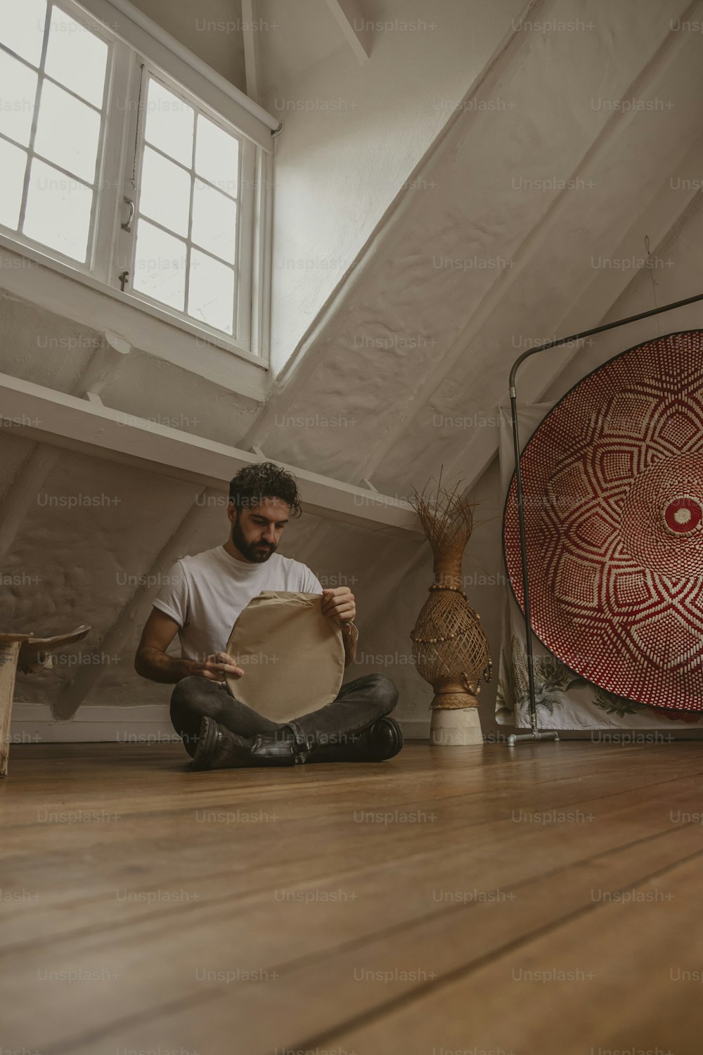 a man sitting on the floor holding a plate