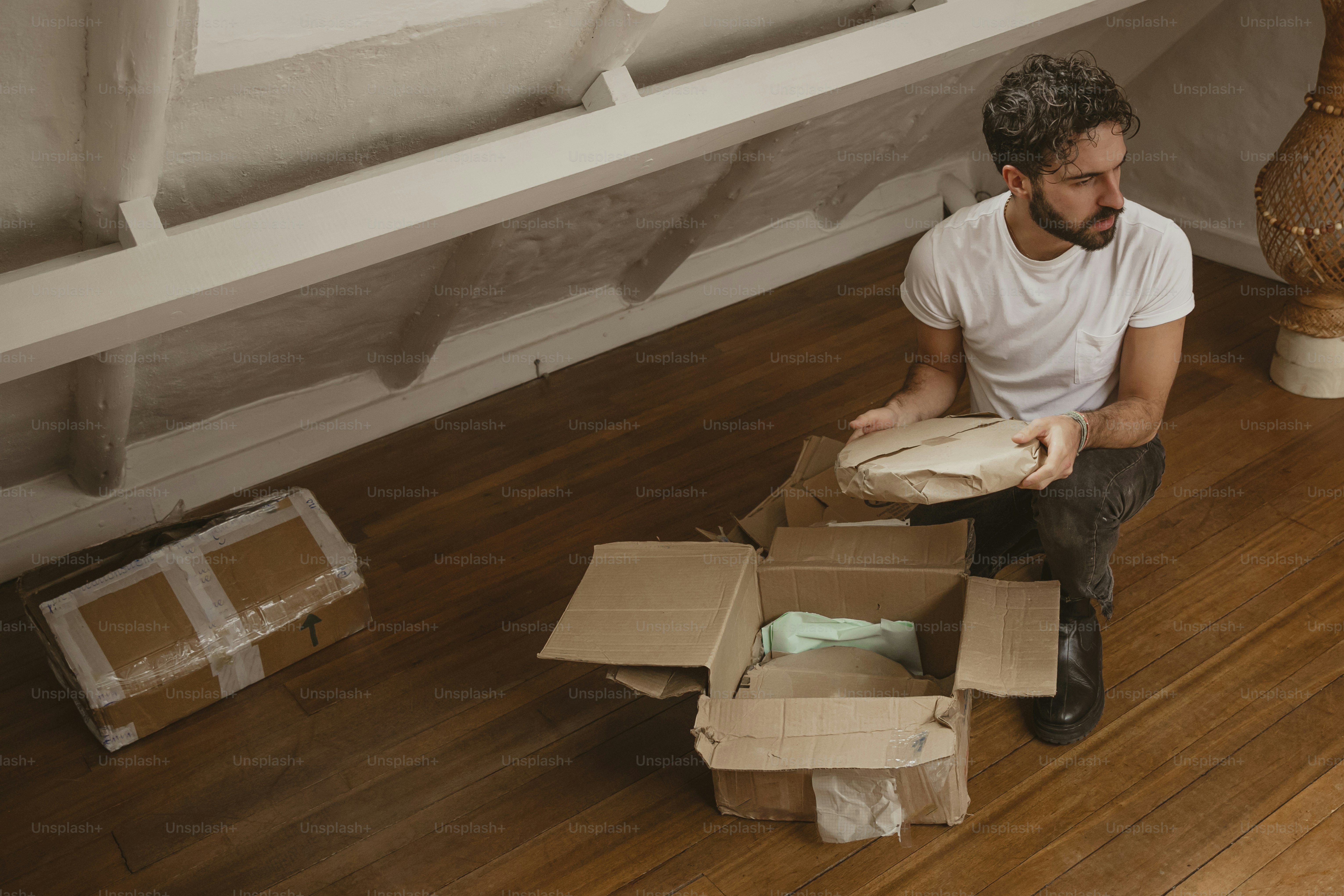 a man sitting on the floor holding a box