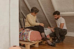 a man and a woman sitting on a bed