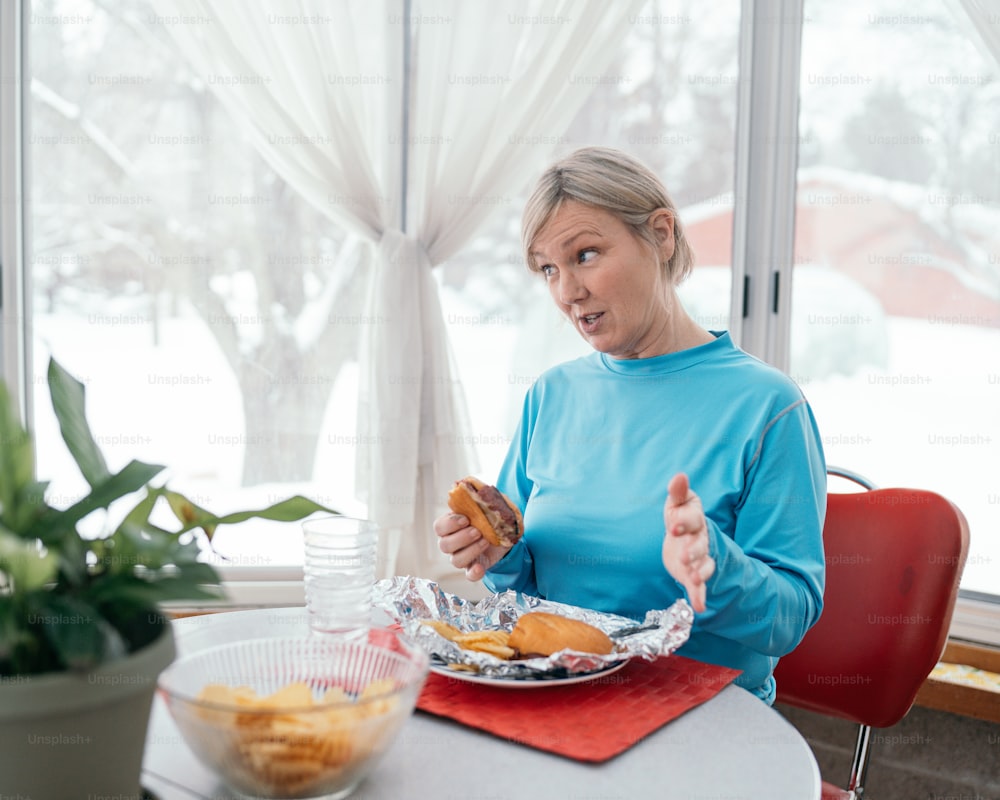 uma mulher sentada em uma mesa com um prato de comida