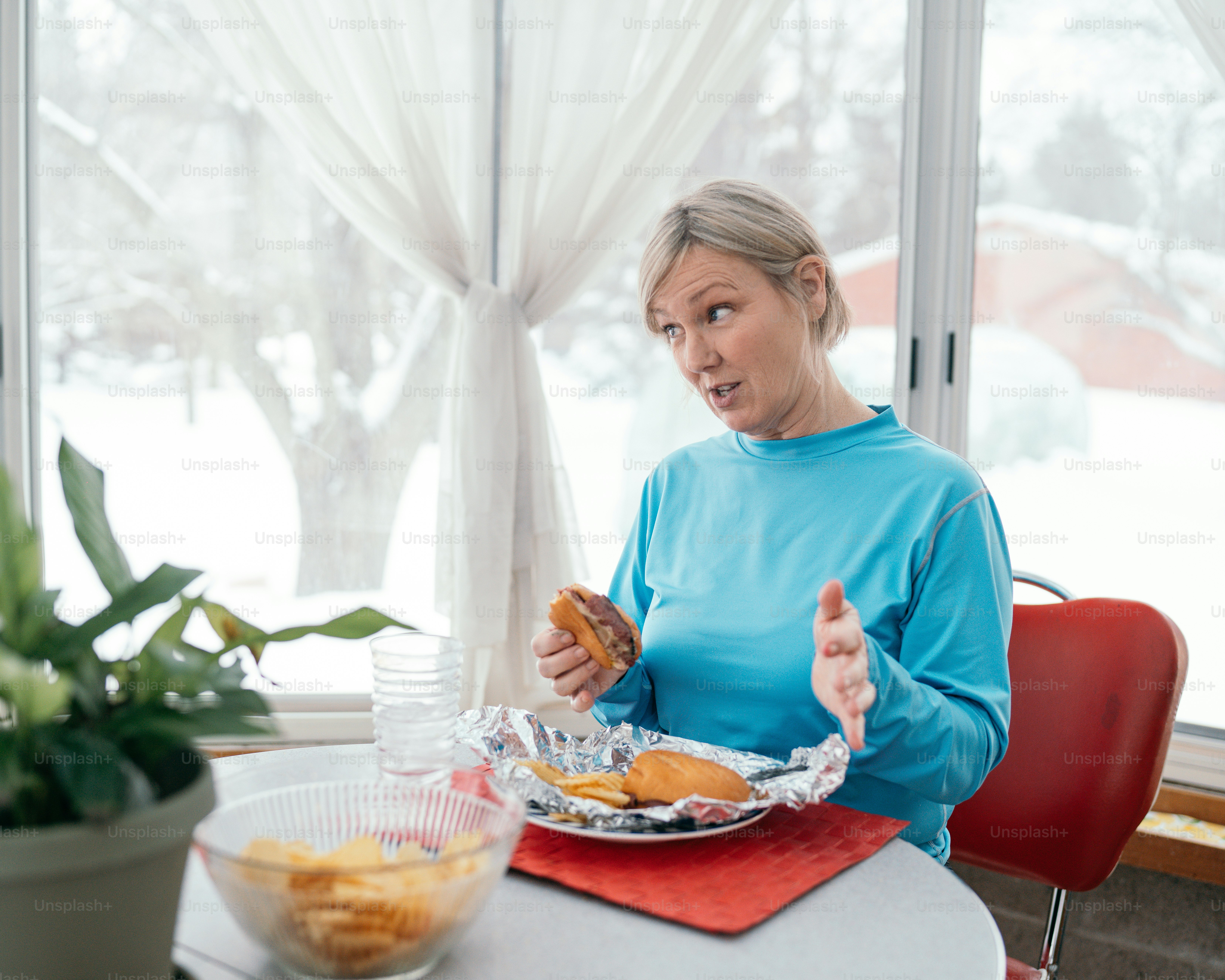 a woman sitting at a table with a plate of food