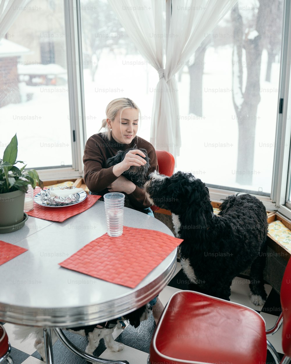 a woman sitting at a table with a dog