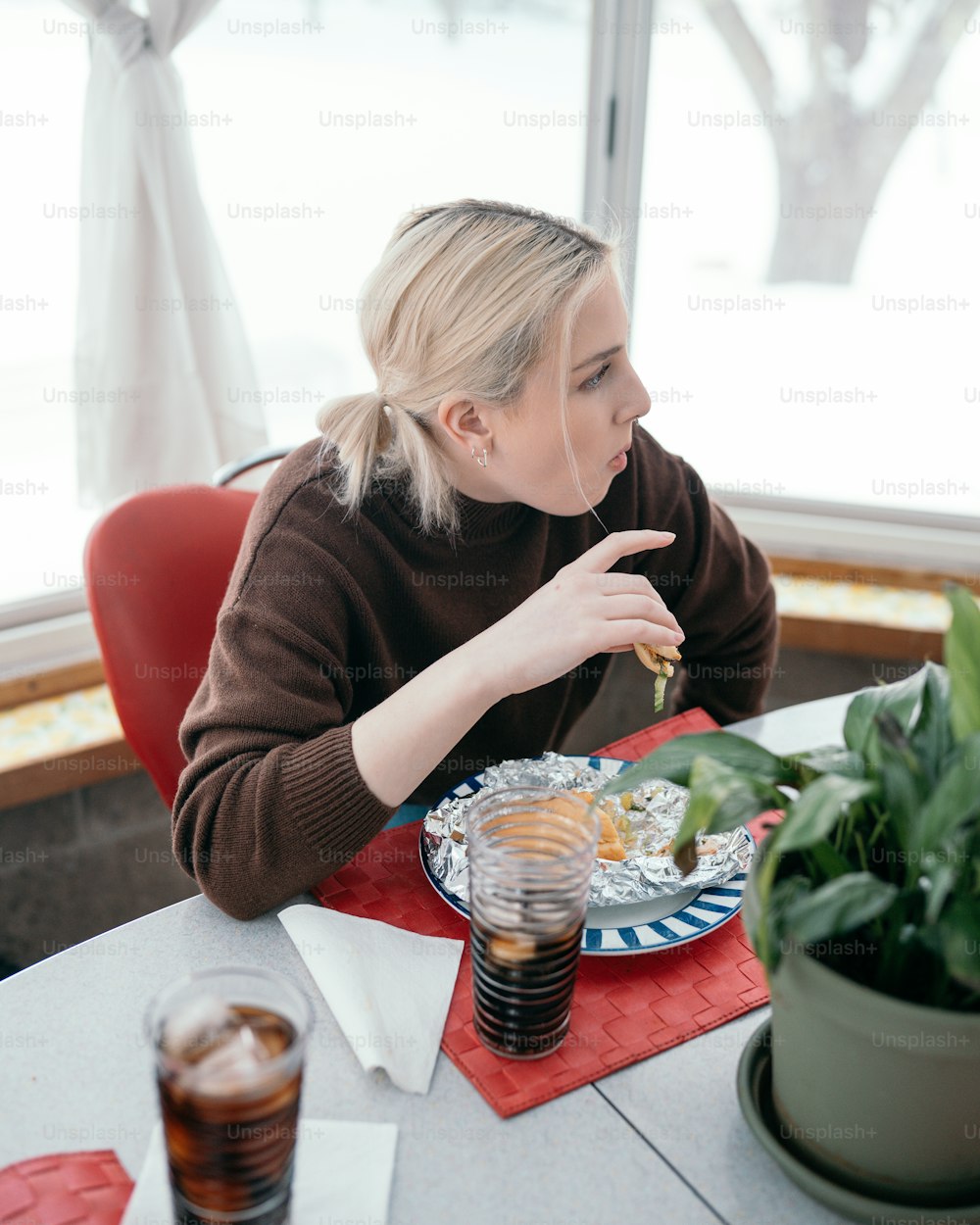 a woman sitting at a table with a plate of food