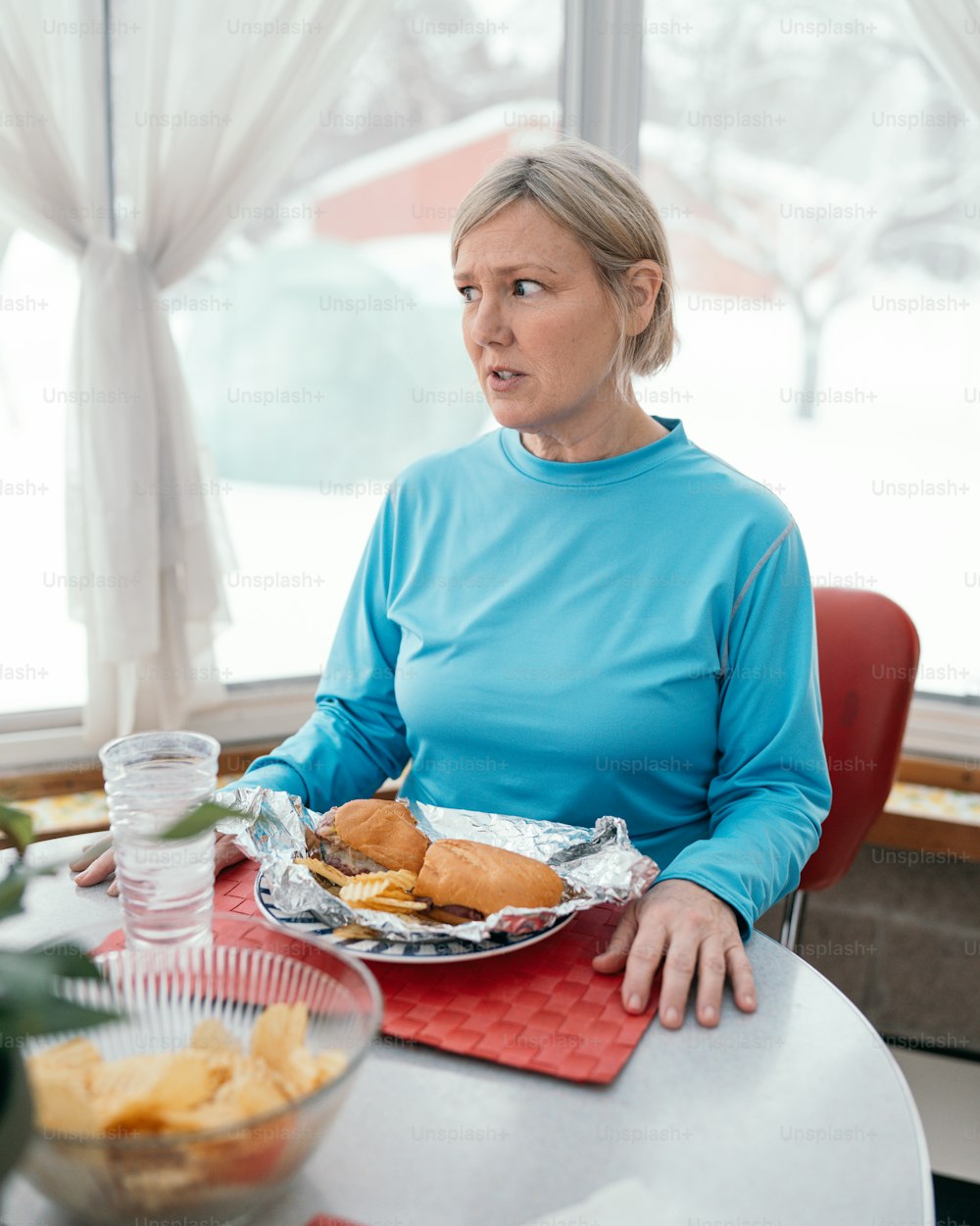 a woman sitting at a table with a plate of food