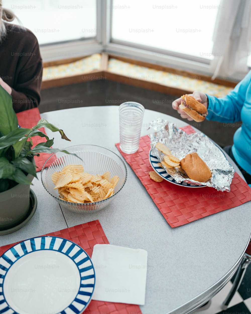 음식 접시가 있는 테이블에 앉아 있는 두 여자