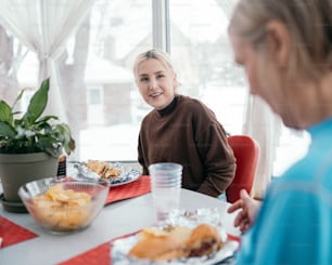 a woman sitting at a table with a plate of food