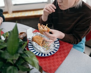 a woman sitting at a table with a plate of food