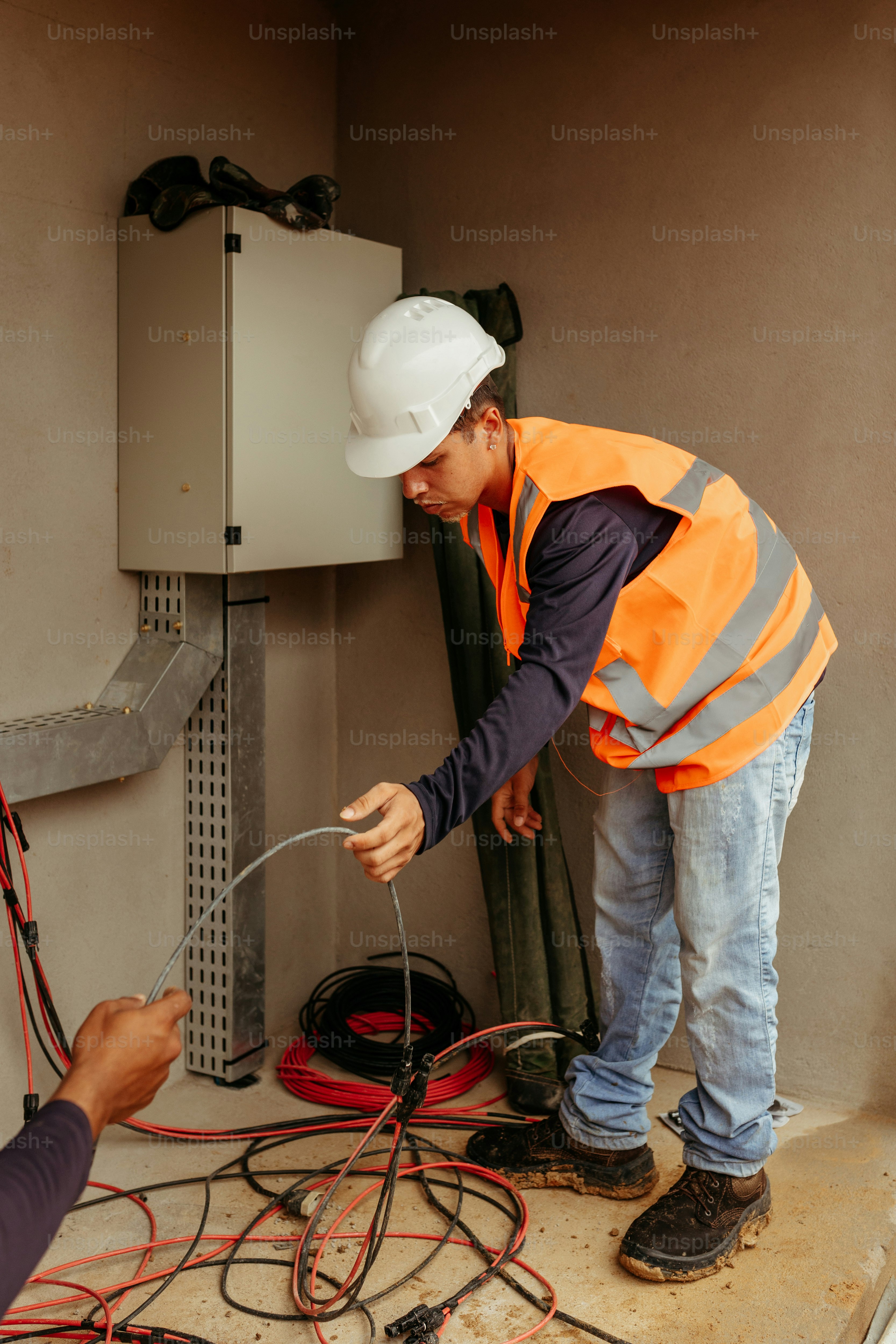 a man in a hard hat and safety vest working on a machine