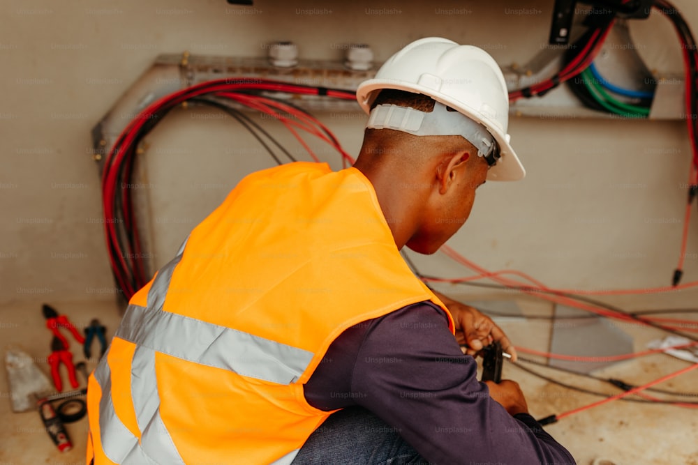 a man in a safety vest working on a pipe