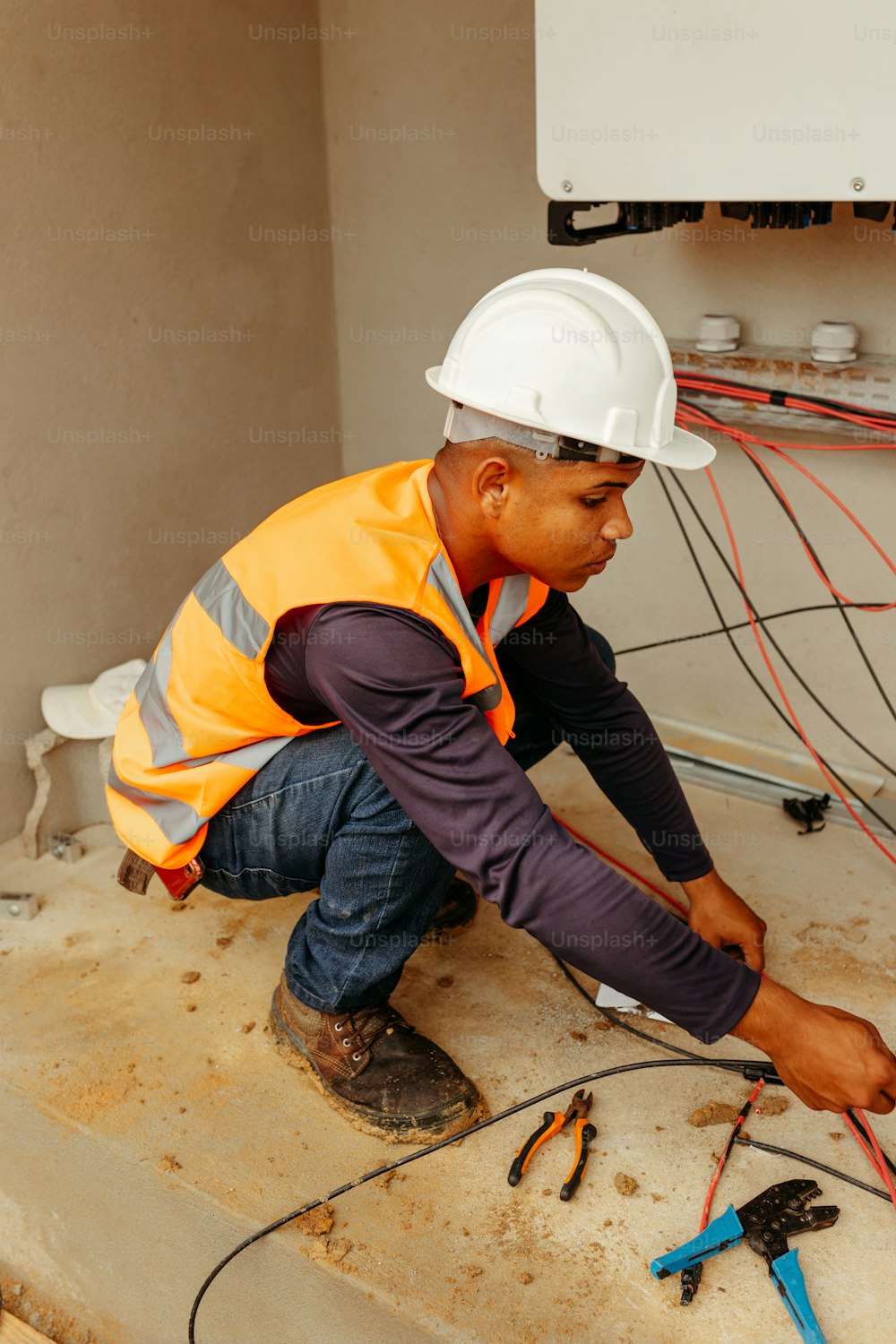 a man in a hard hat working on a wall