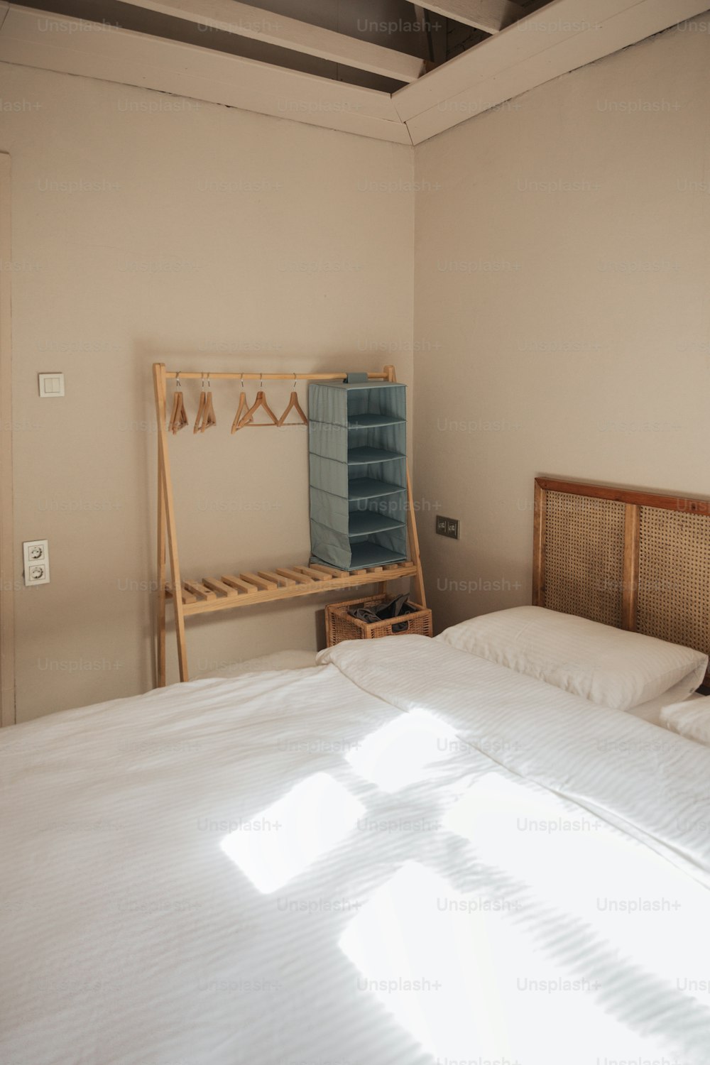 a bed with white sheets and pillows in a room