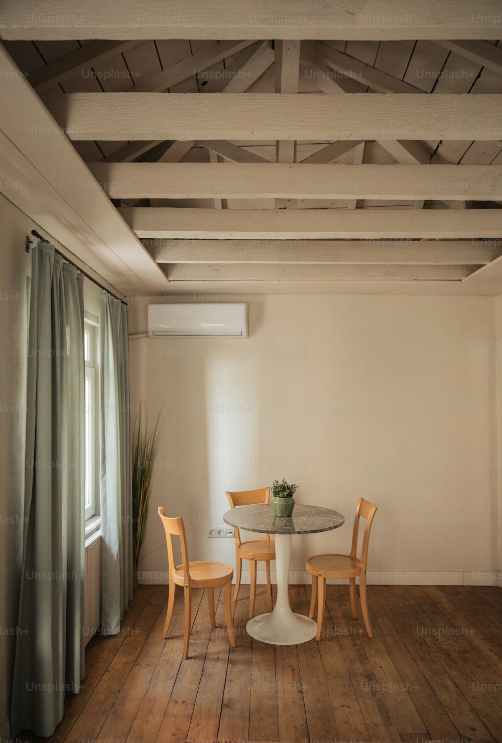 uma mesa e cadeiras em uma sala com piso de madeira