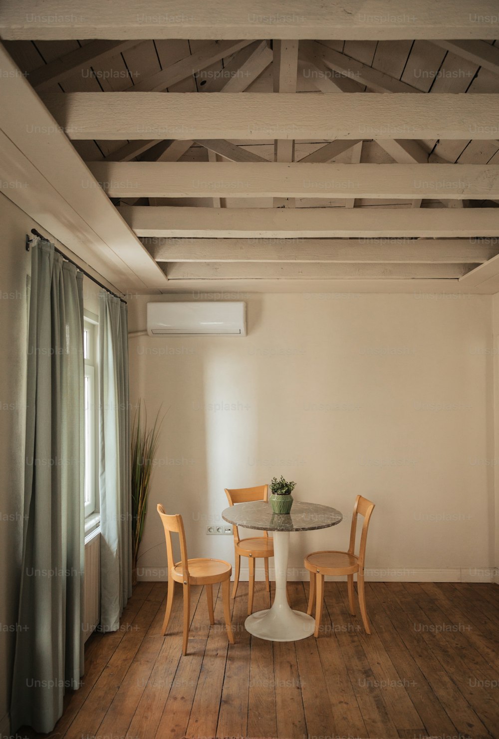 a table and chairs in a room with wood floors