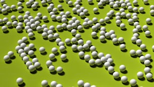 a large group of white balls on a green surface