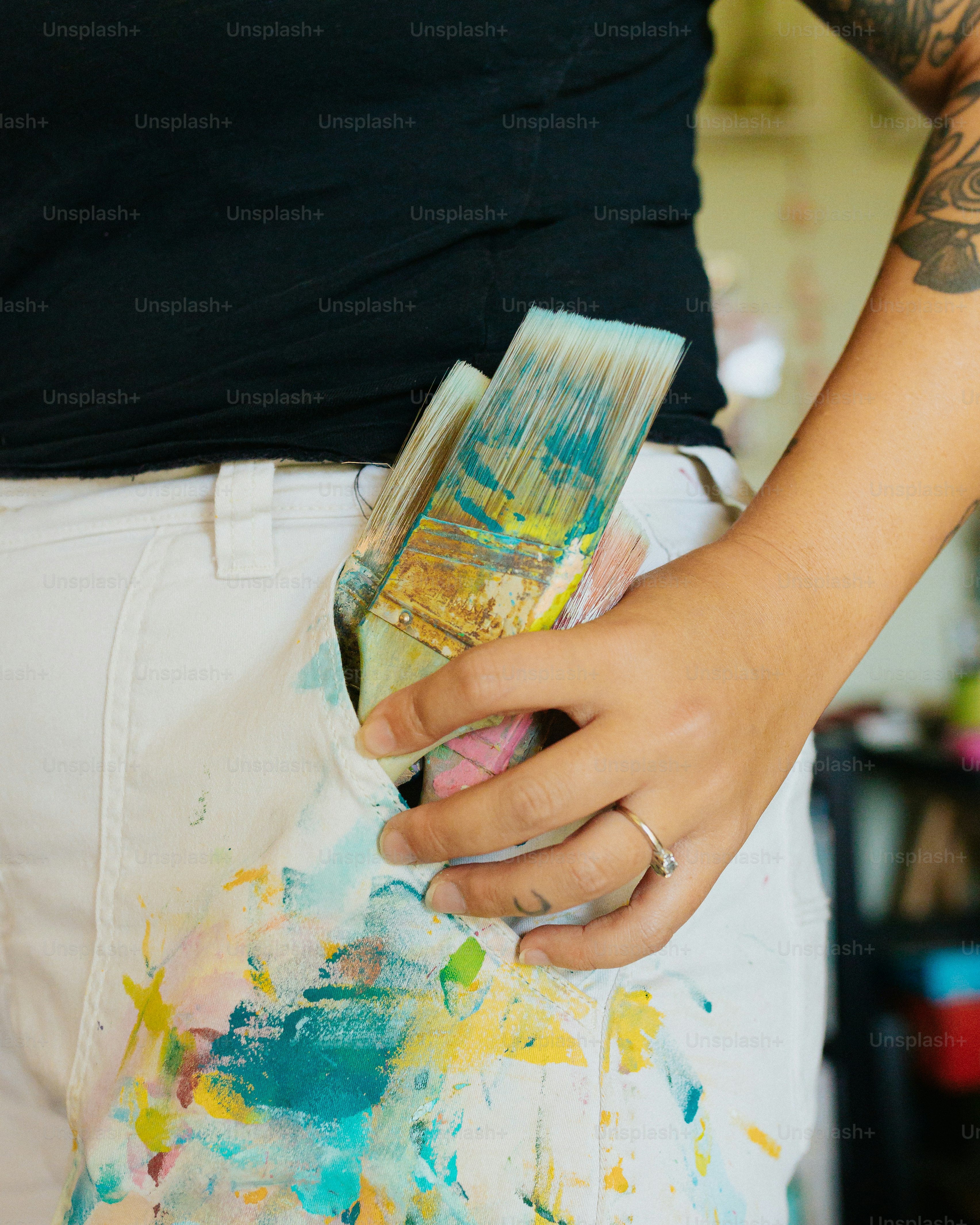 a person holding a paintbrush in their left hand