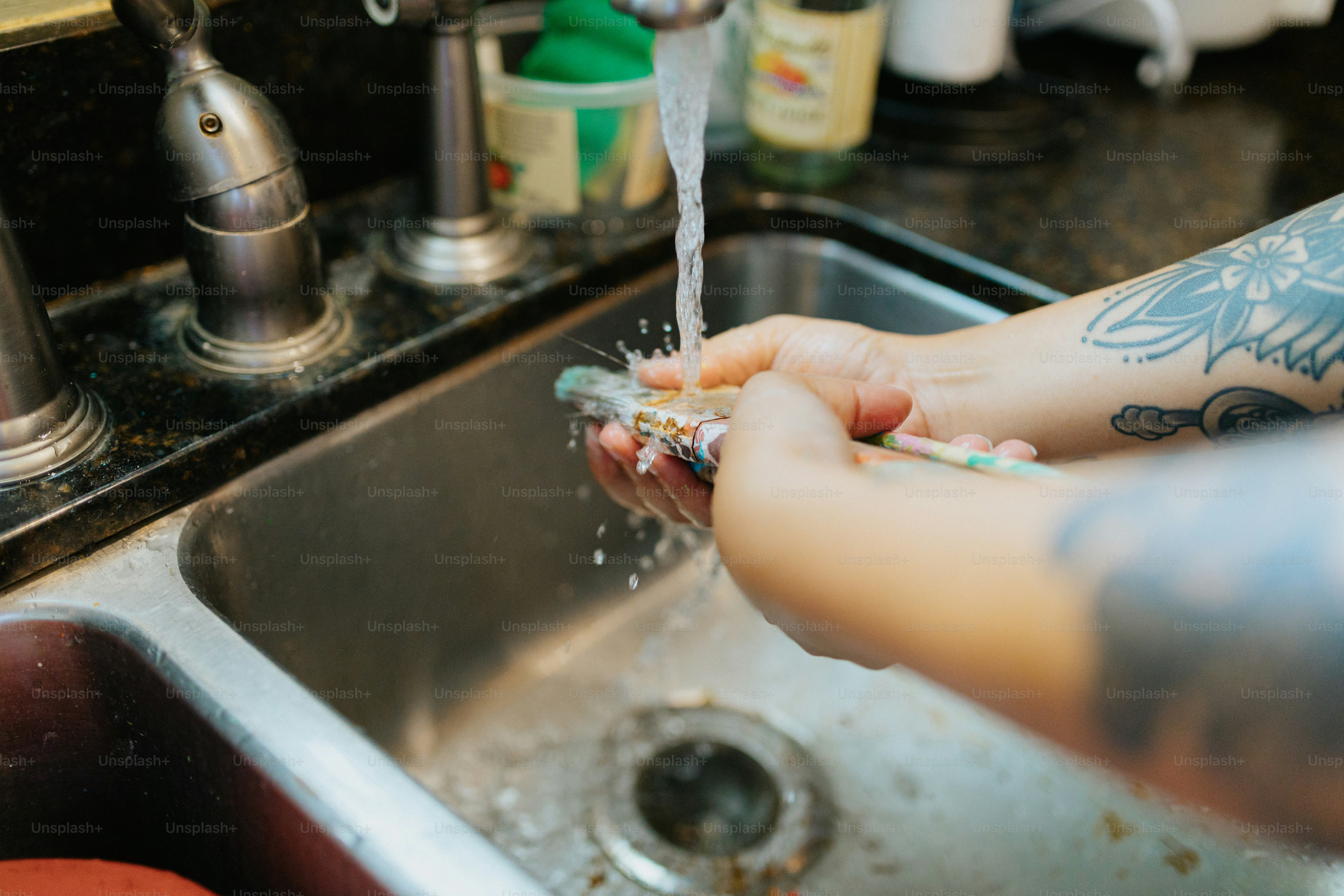 a person washing their hands in a sink