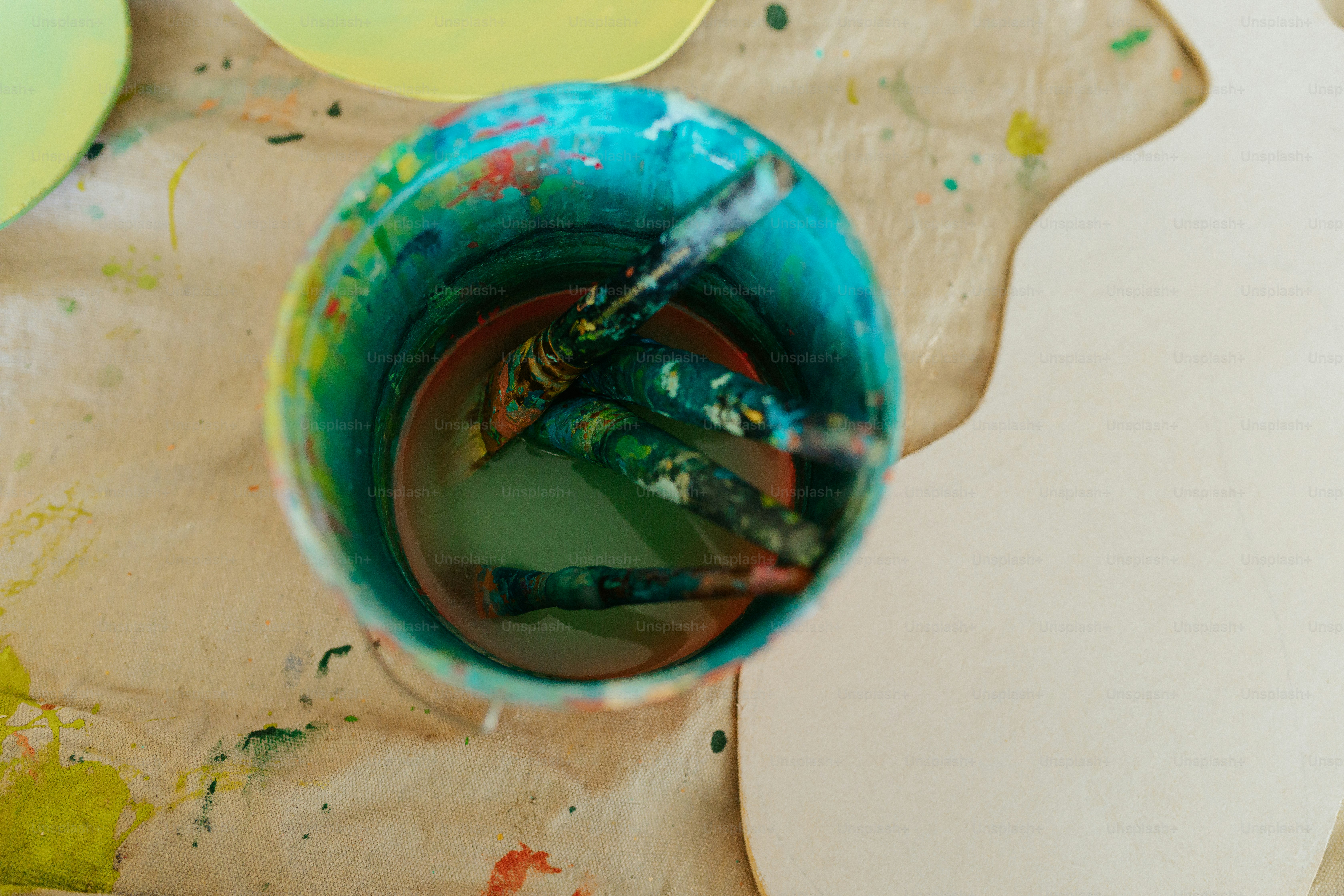 a blue cup filled with paint sitting on top of a table