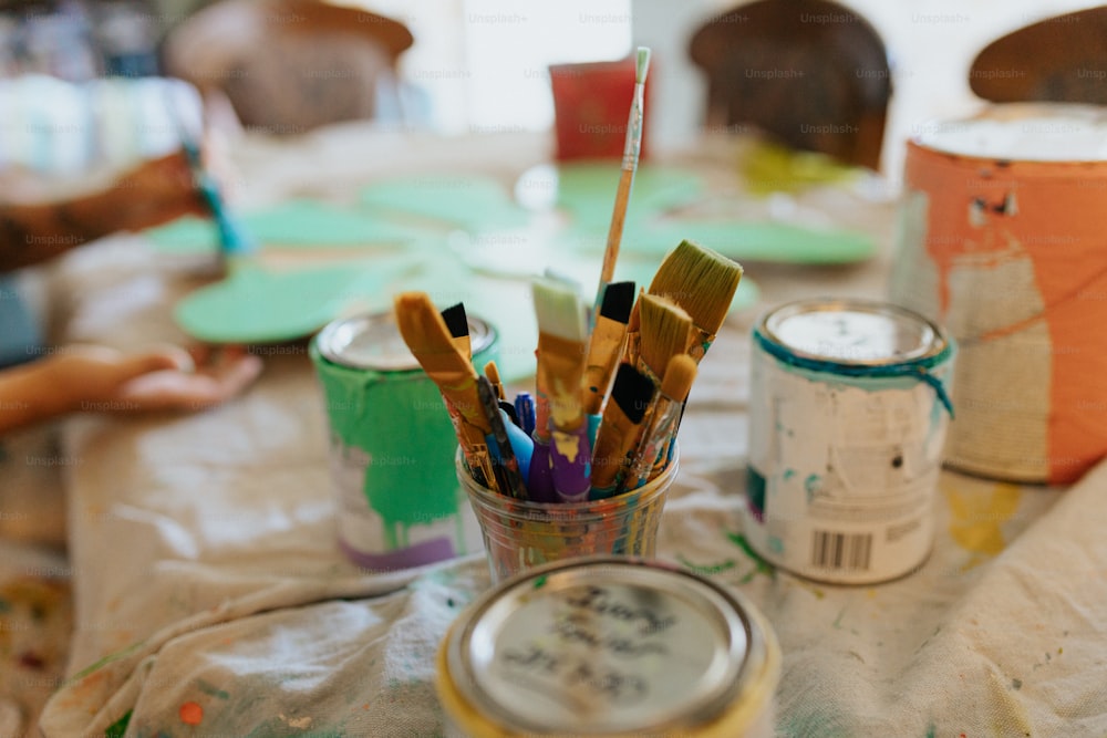 a cup filled with lots of paint brushes