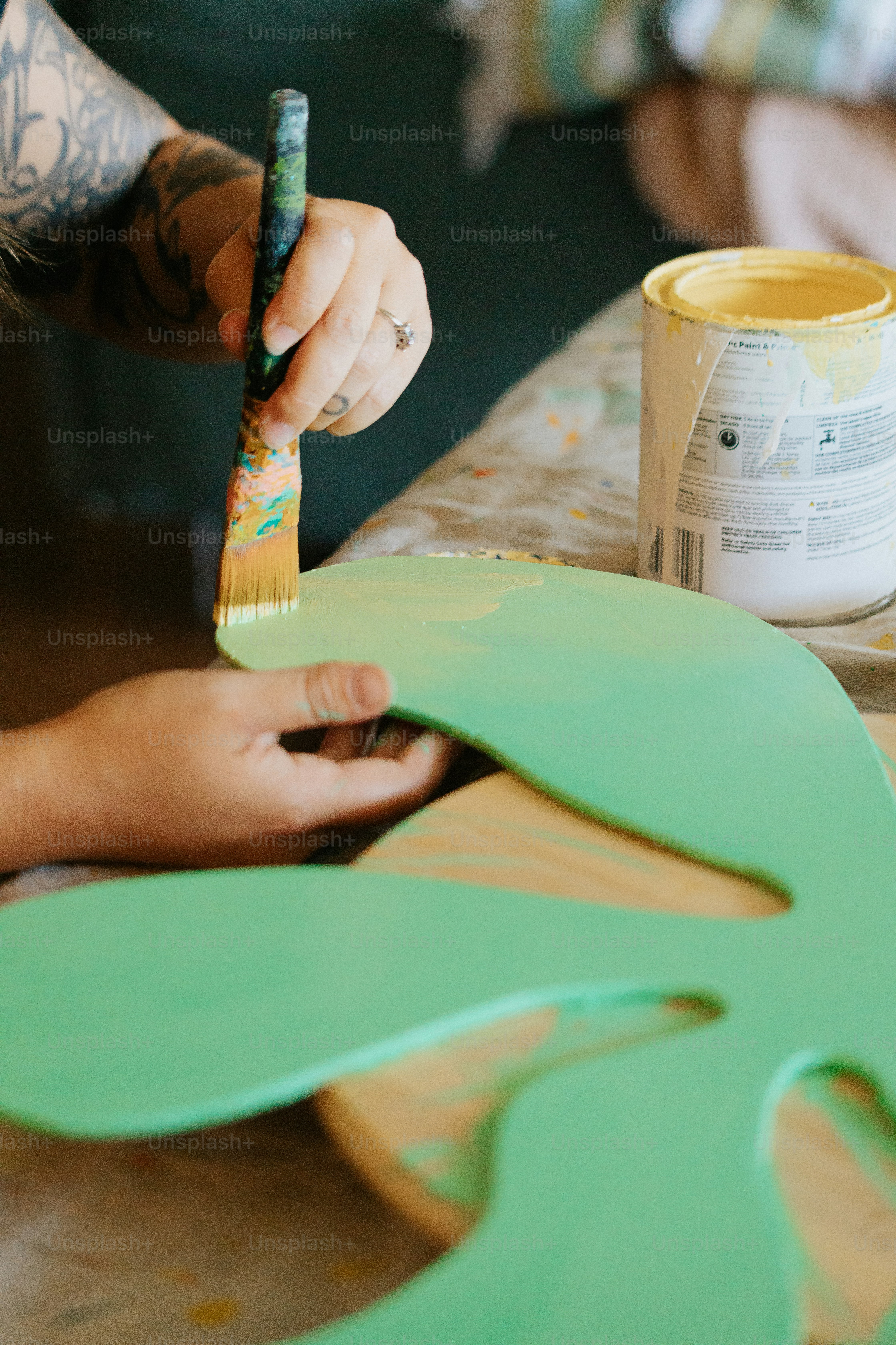 a person with a paintbrush painting a piece of wood