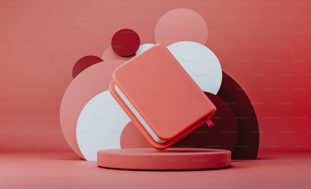 Ein rotes Buch, das auf einem rosa Objekt sitzt