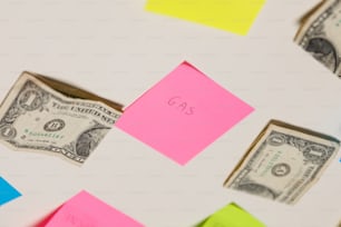 a piece of pink paper sitting on top of a pile of post it notes