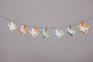 a string of money hanging from a clothes line
