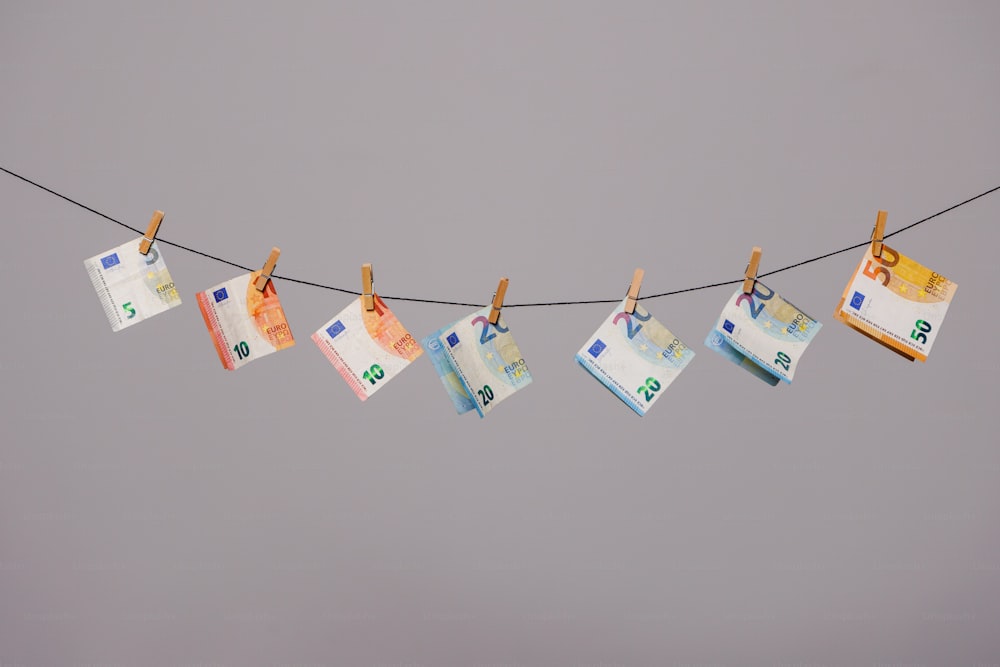 a string of money hanging from a clothes line