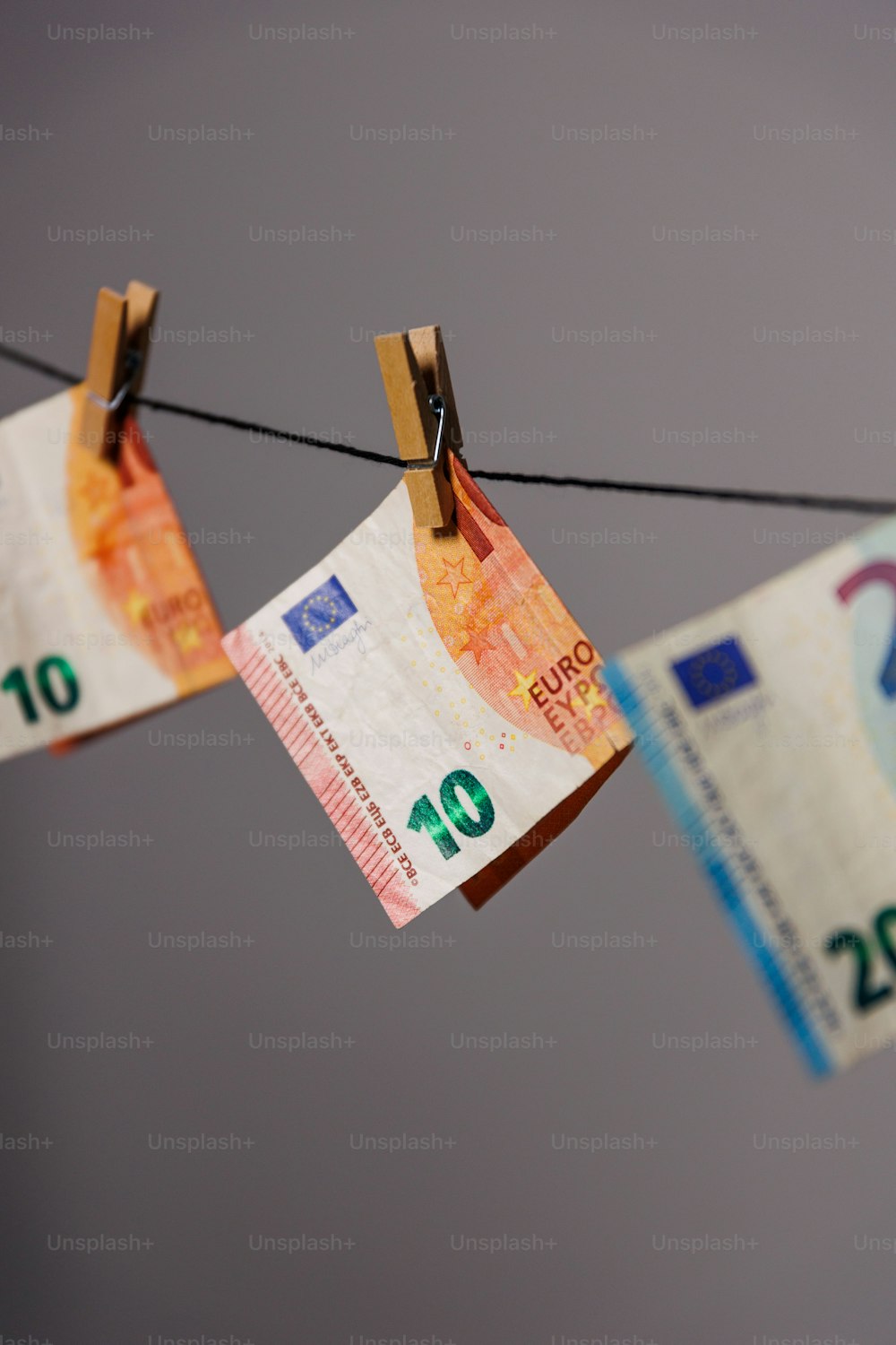 a bunch of money hanging on a clothes line