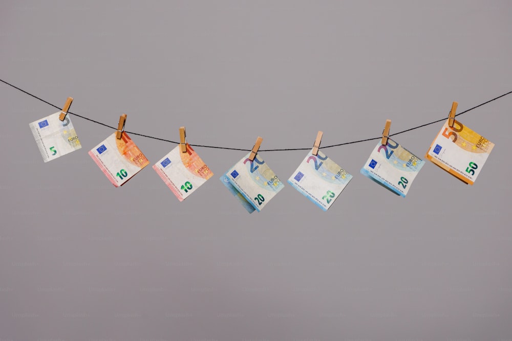a bunch of money hanging from a clothes line