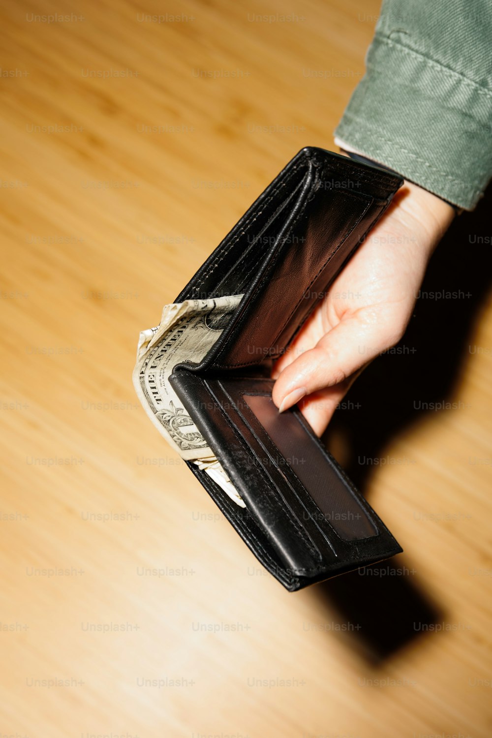 a person is holding a wallet and money