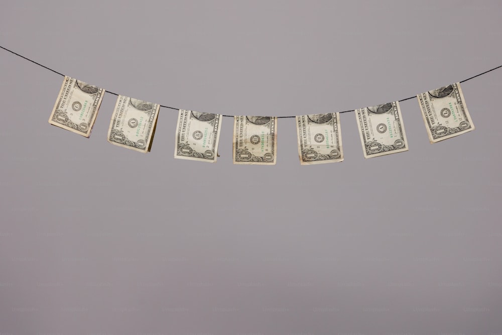 uma série de notas de dólar penduradas em um varal