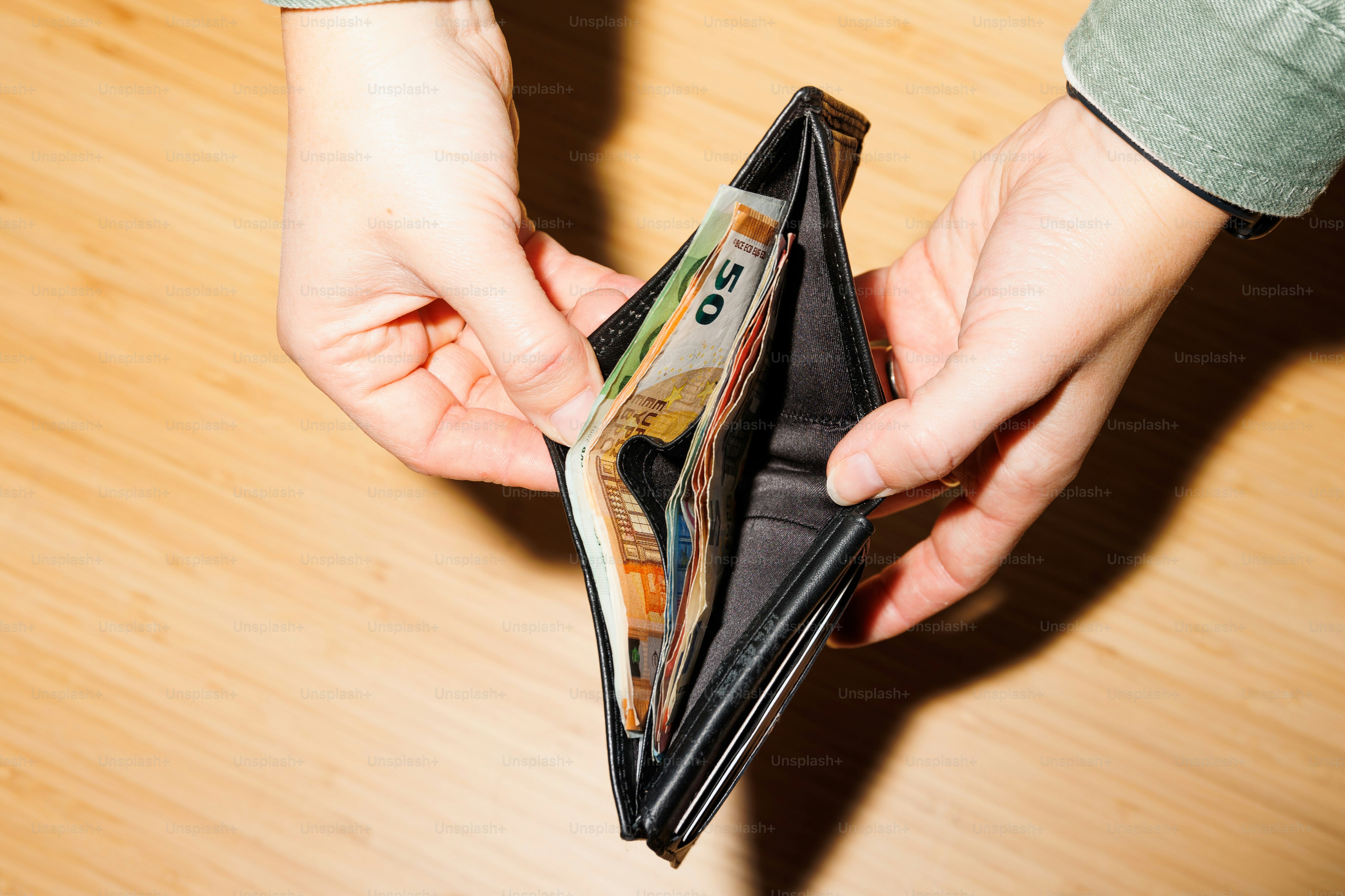 a person is holding a wallet with money in it