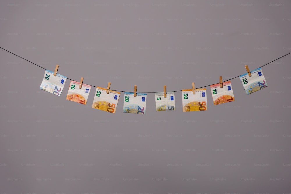 a number of different currency bills hanging on a clothes line
