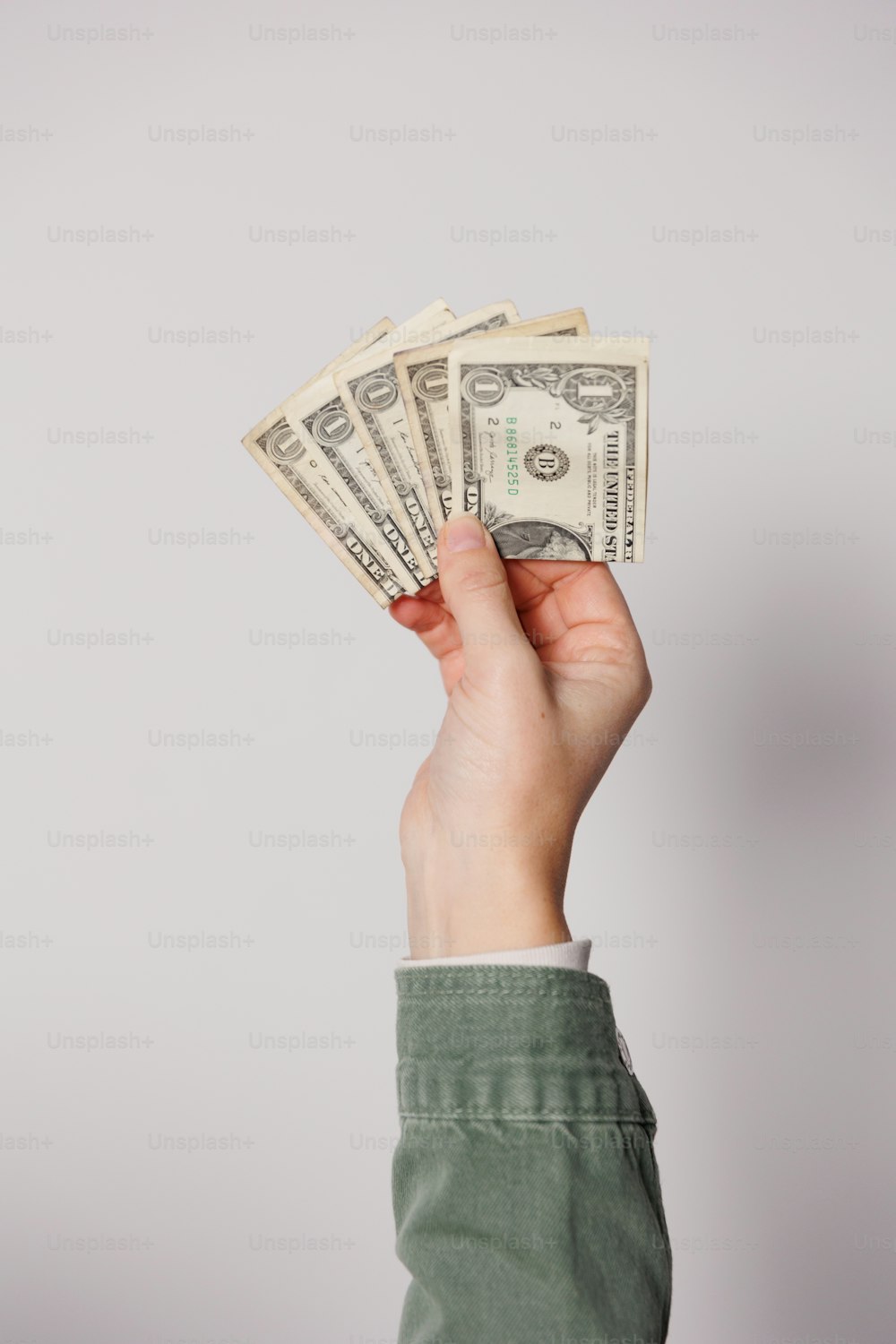 a person holding a stack of money in their hand