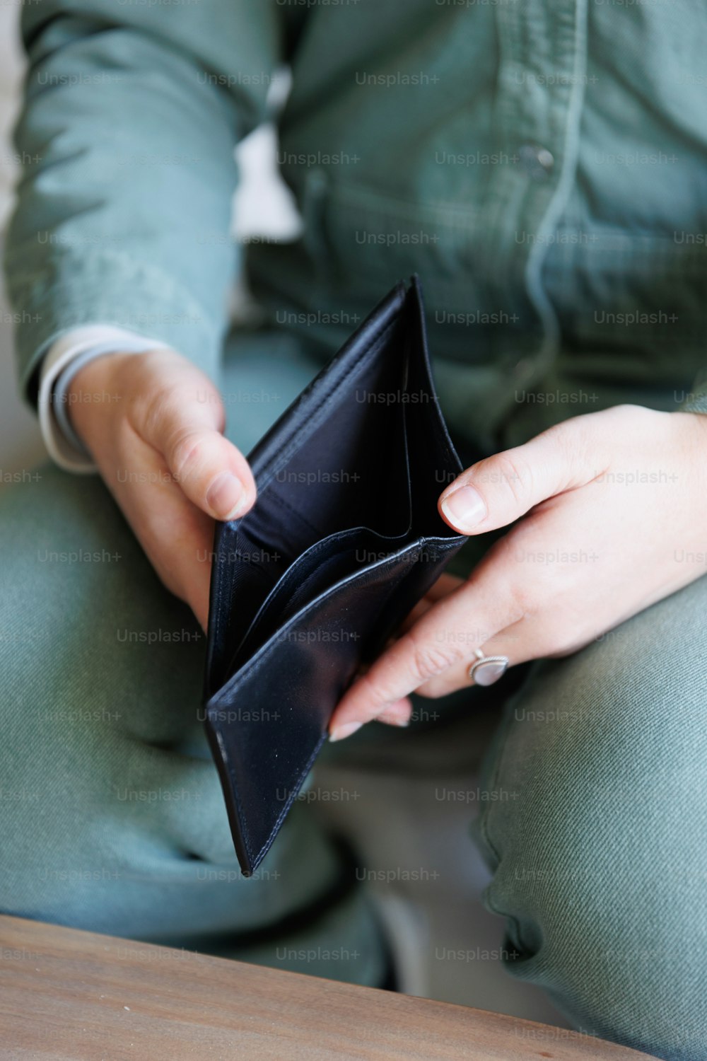 a person sitting down holding an empty wallet