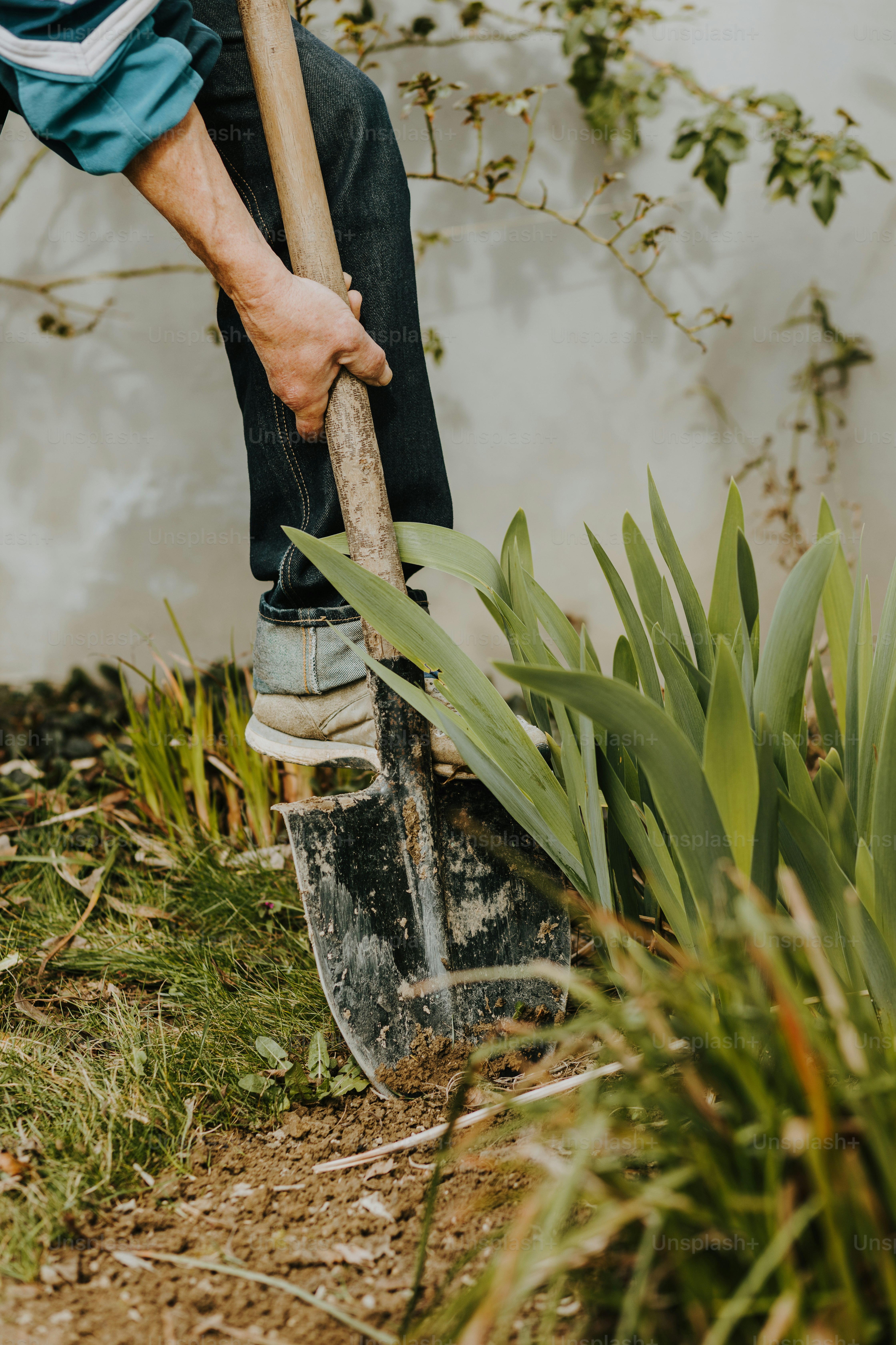 a man holding a shovel and digging in the dirt