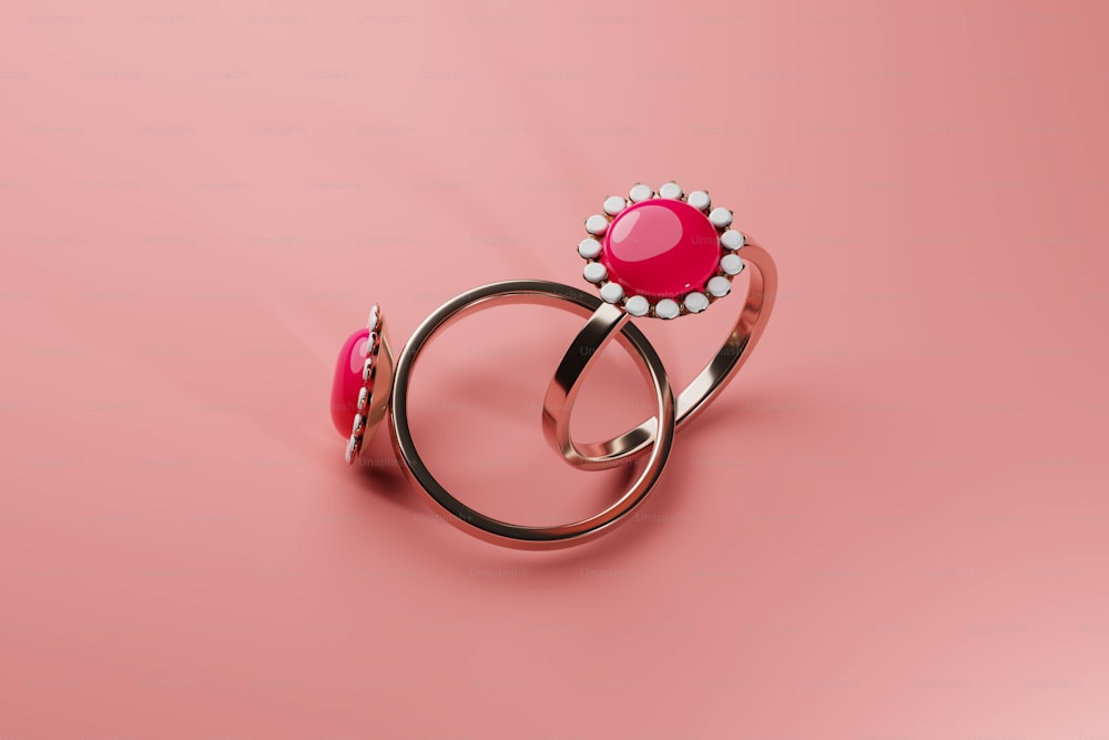 a pair of rings with a pink stone in the middle